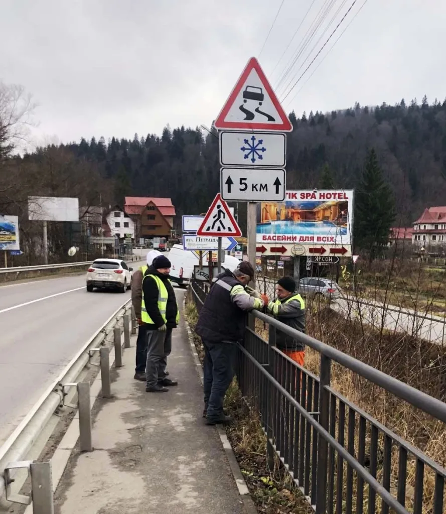 Робітники ремонтують огорожу біля дороги в горах
