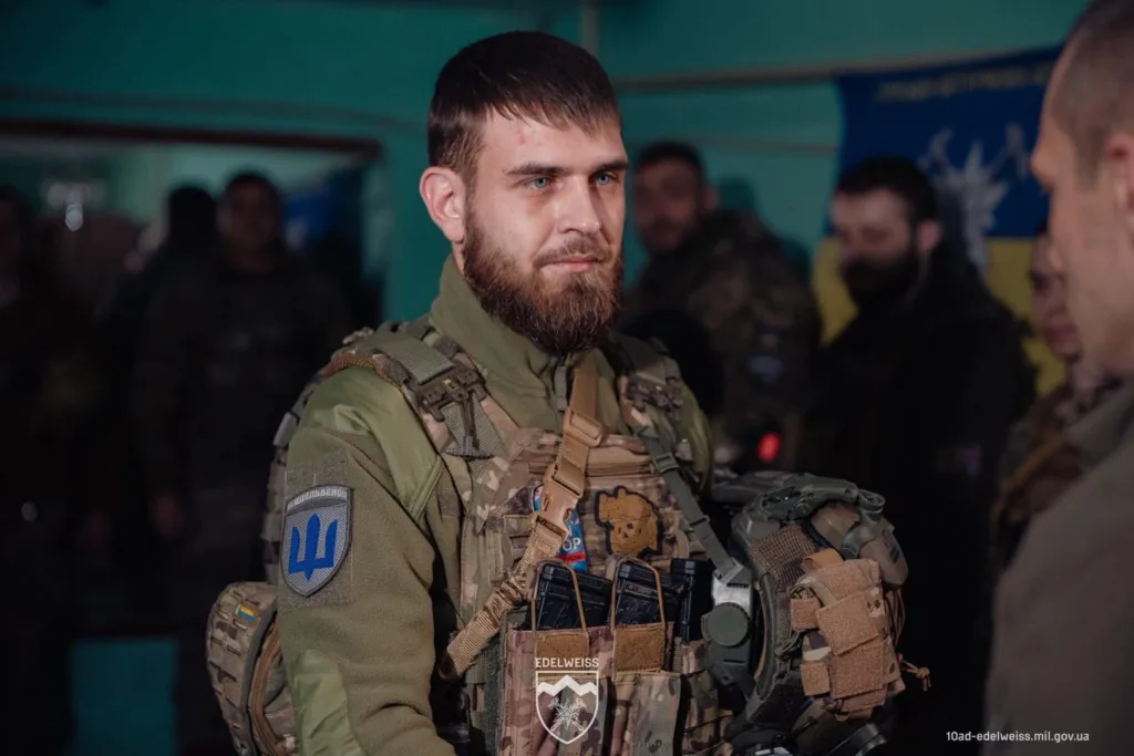 Український військовий у камуфляжі тримає шолом