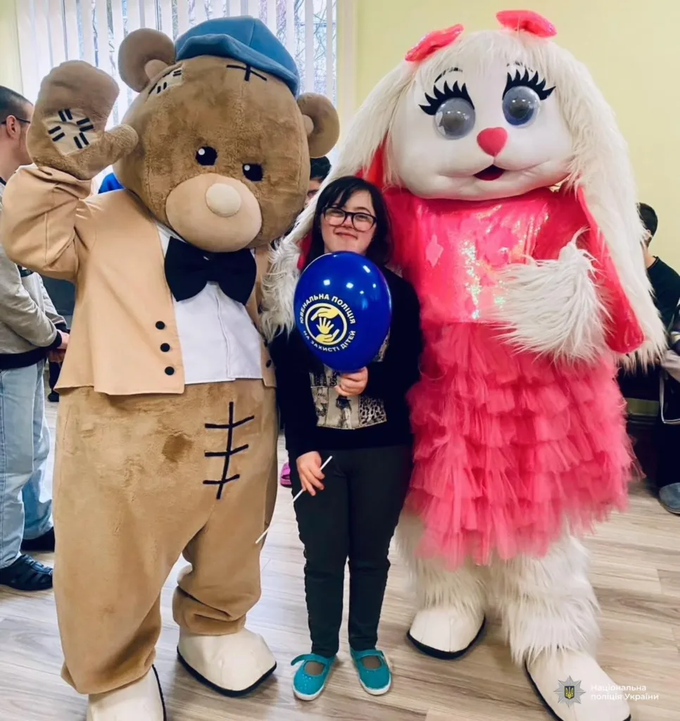 Дитина з героями у костюмах ведмедя та кролика