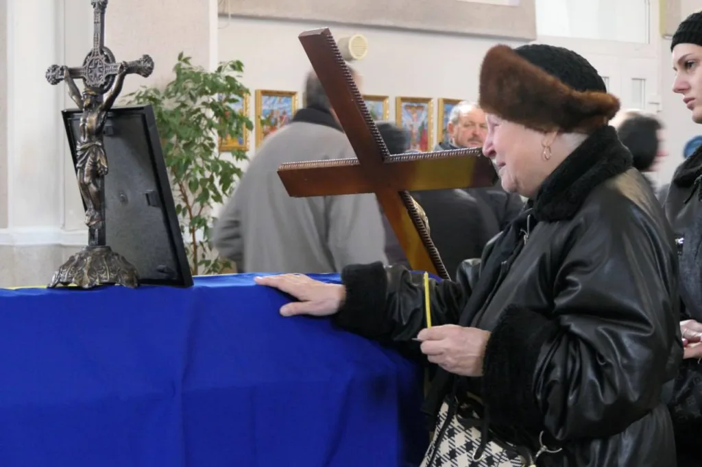 Жінка молиться перед хрестом у церкві