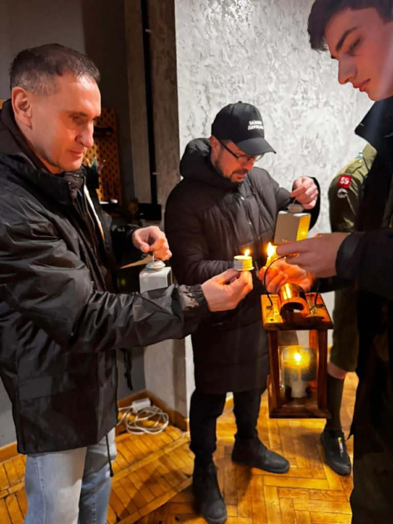 Люди запалюють свічки від вогню у ліхтарі