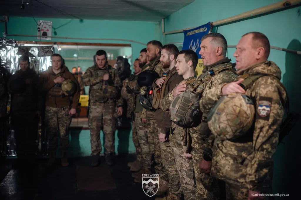 Українські військові стоять зі шоломами під час присяги