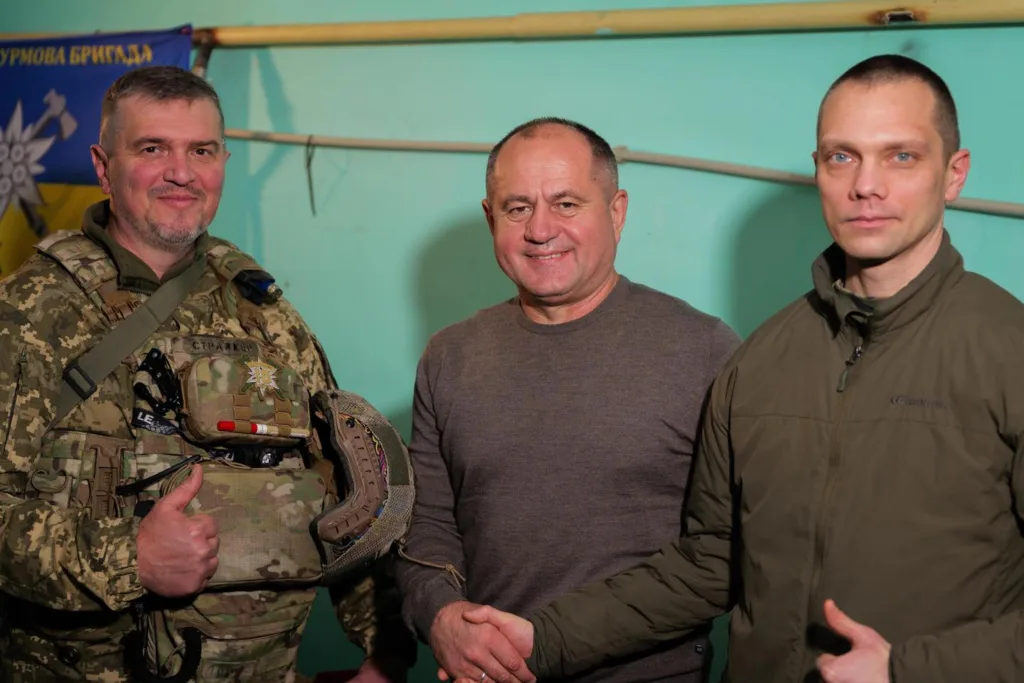 Військові та цивільний потискають руки