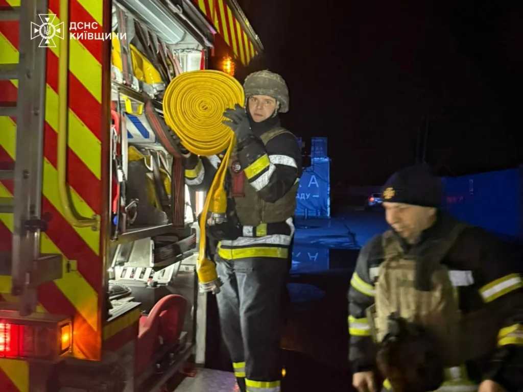 Пожежники готують обладнання біля пожежного автомобіля