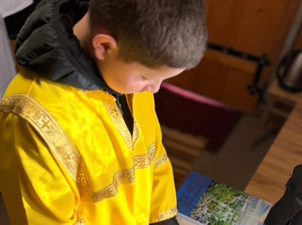 Хлопець у жовтому вбранні читає книгу