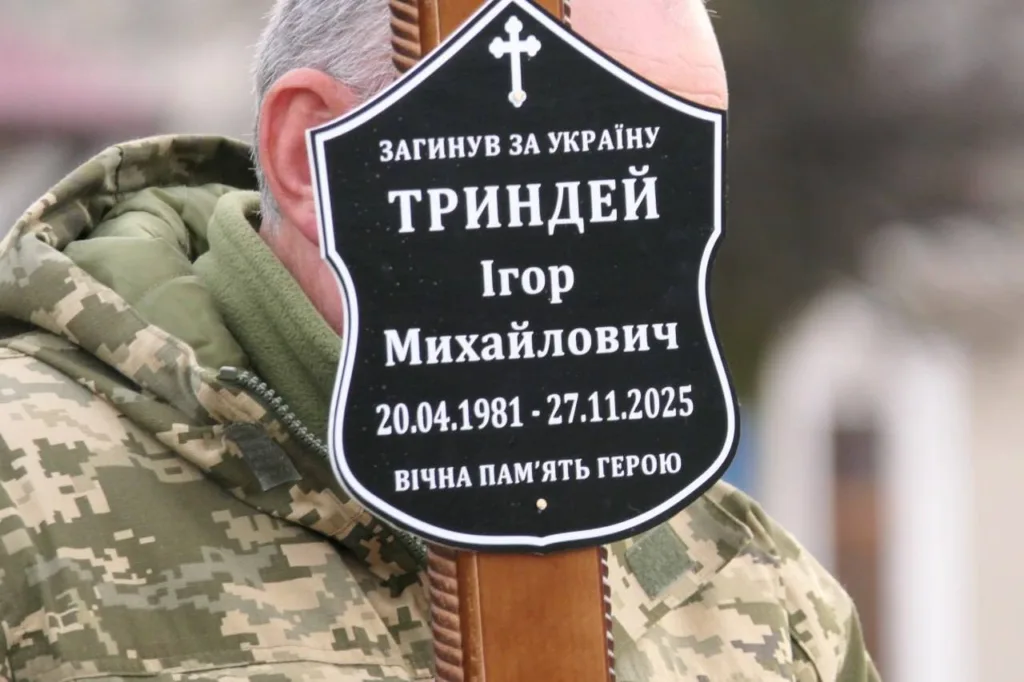 Військовий тримає меморіальну табличку героя