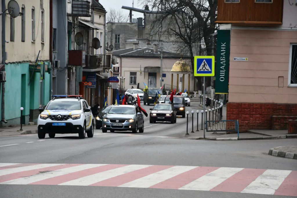 Автоколона з українськими прапорами на міській вулиці
