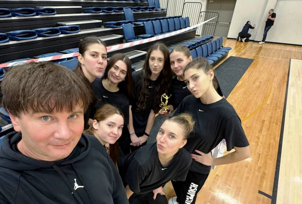 Команда дівчат з трофеєм у спортивному залі