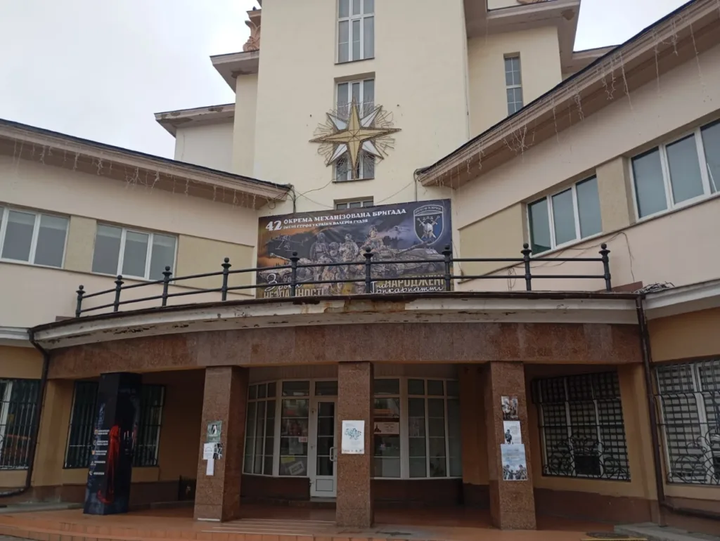 Будівля з плакатом військової бригади на фасаді