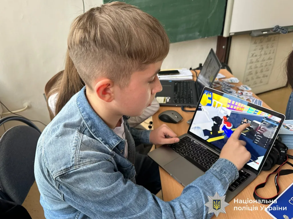 Учень працює за ноутбуком у шкільному класі