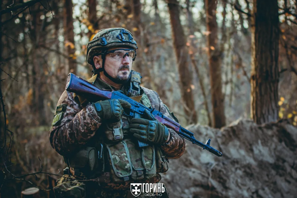 Український військовий у лісі з автоматом