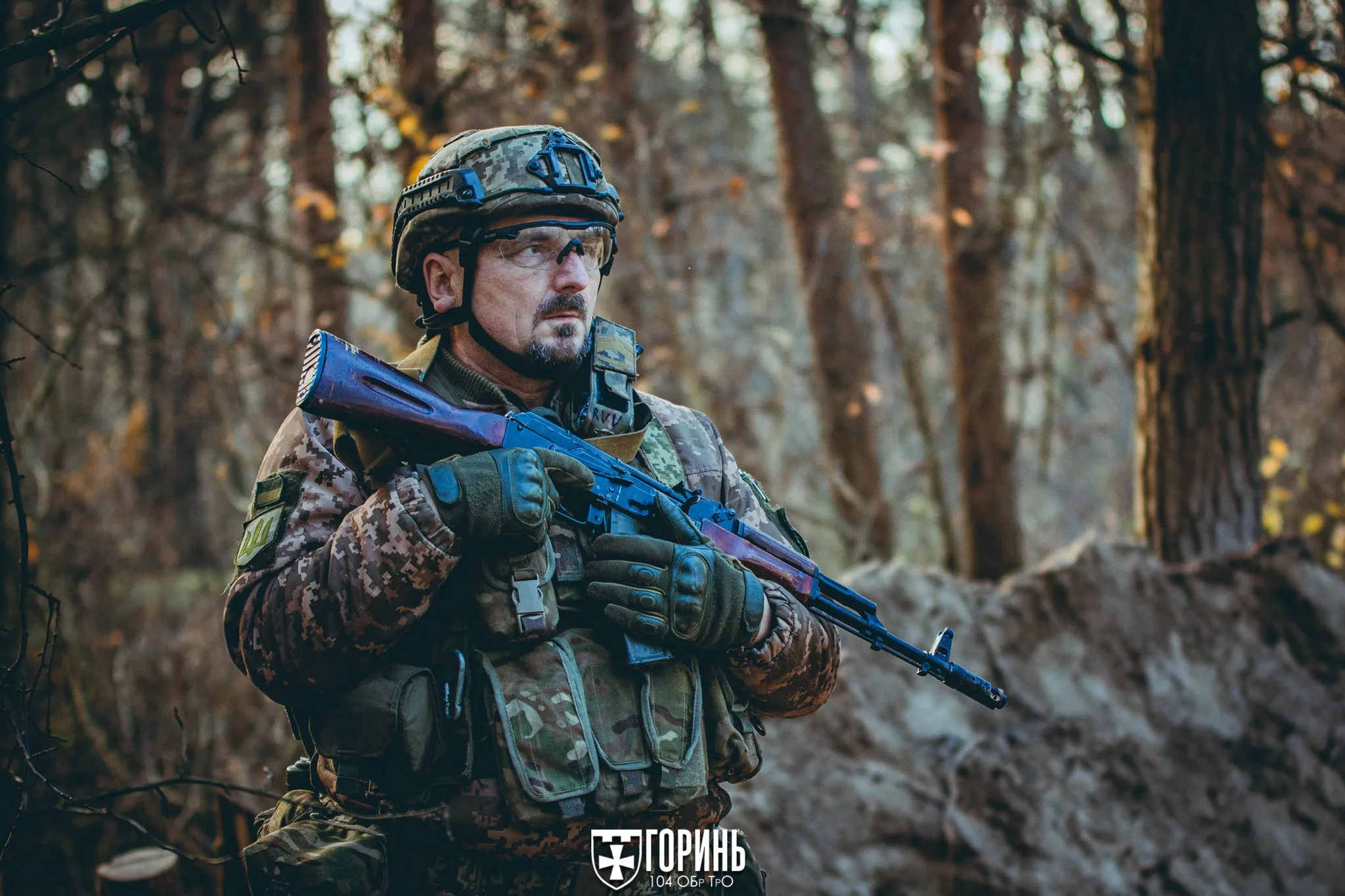 Український військовий у лісі з автоматом