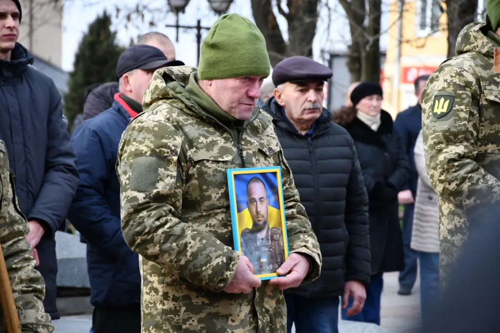 Військовий тримає фото загиблого героя України