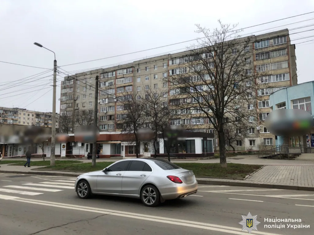 Срібний автомобіль на вулиці біля багатоповерхівки