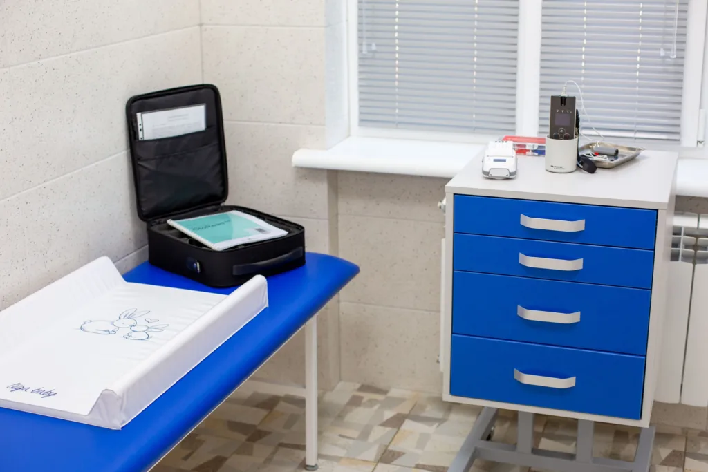 Медичний кабінет із синьою кушеткою та обладнанням