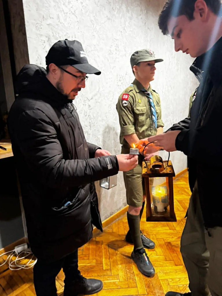 Передача Вифлеємського вогню між скаутами та чоловіком