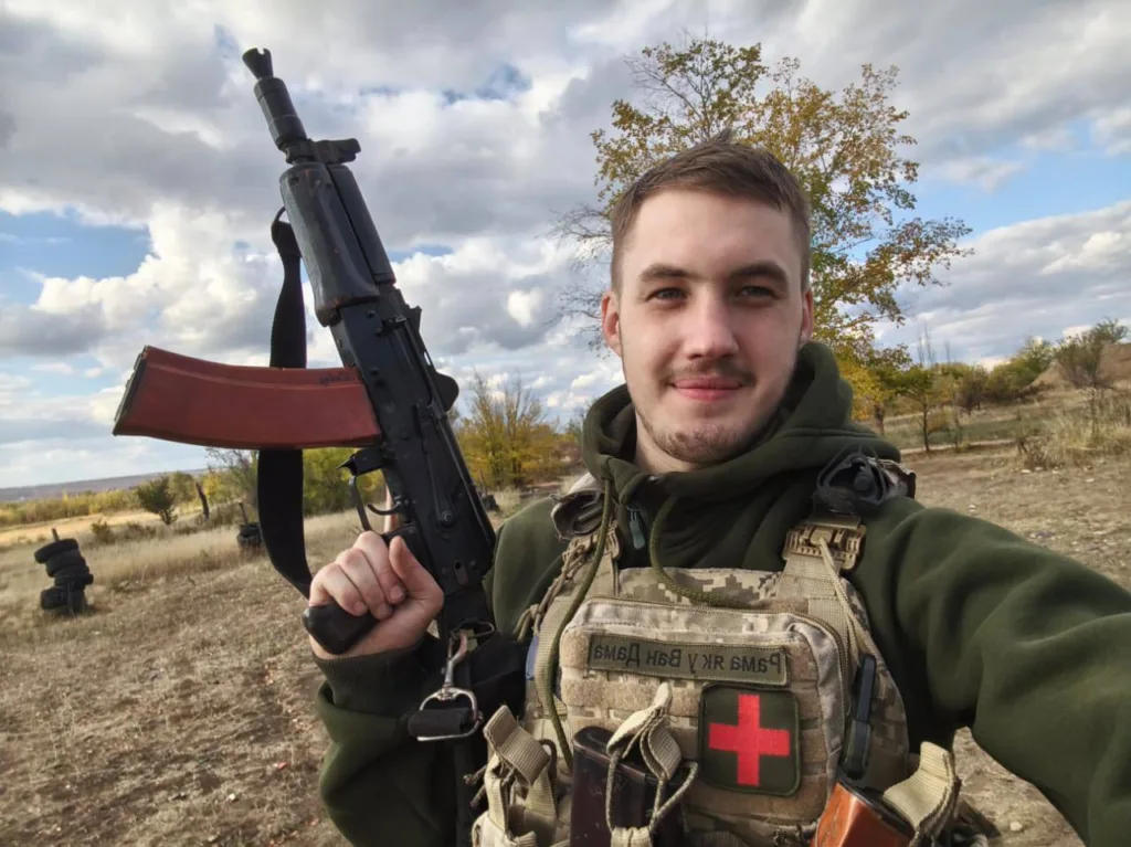 Військовий медик з автоматом на відкритій місцевості