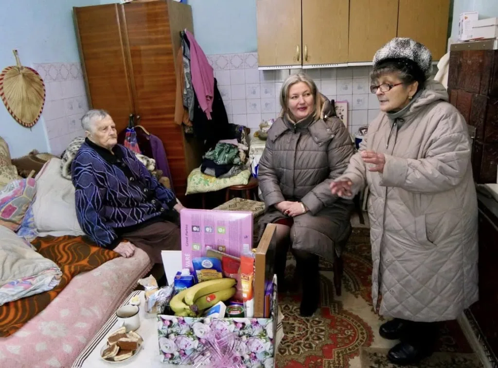 Жінки спілкуються вдома біля подарункового кошика з їжею