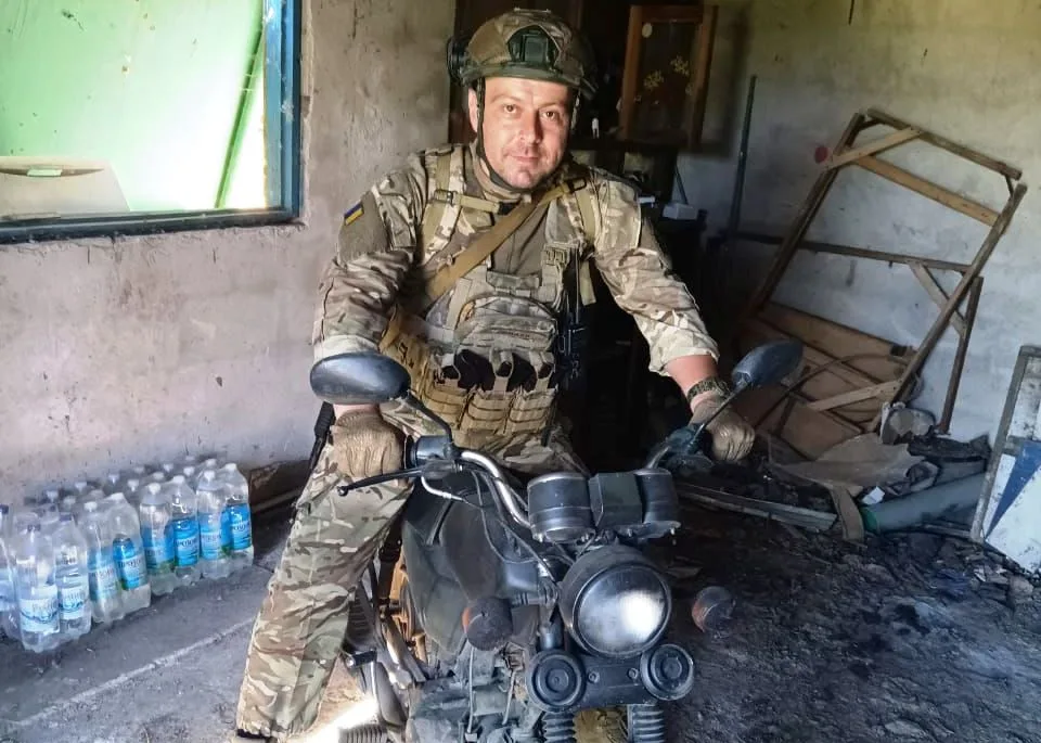 Український військовий на мотоциклі в укритті