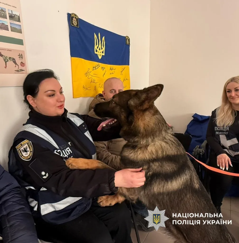 Поліцейські спілкуються з собакою у відділку