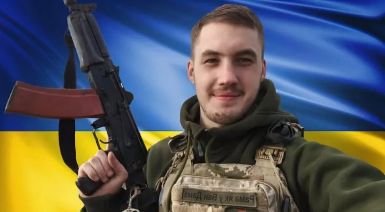 Український військовий перед прапором України