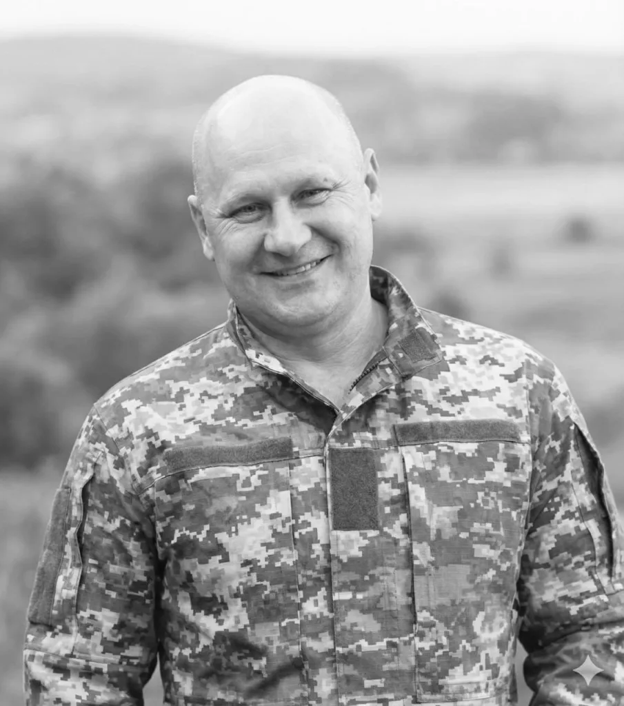 Чоловік у військовій формі посміхається на природі