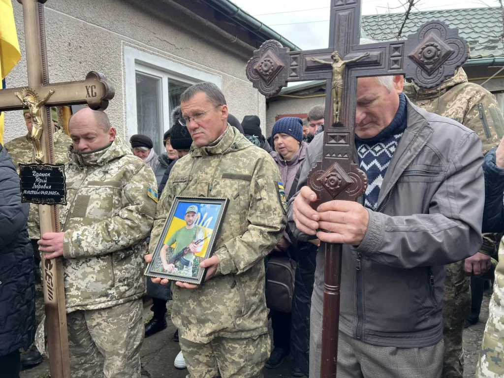 Військові тримають хрести та фото загиблого героя