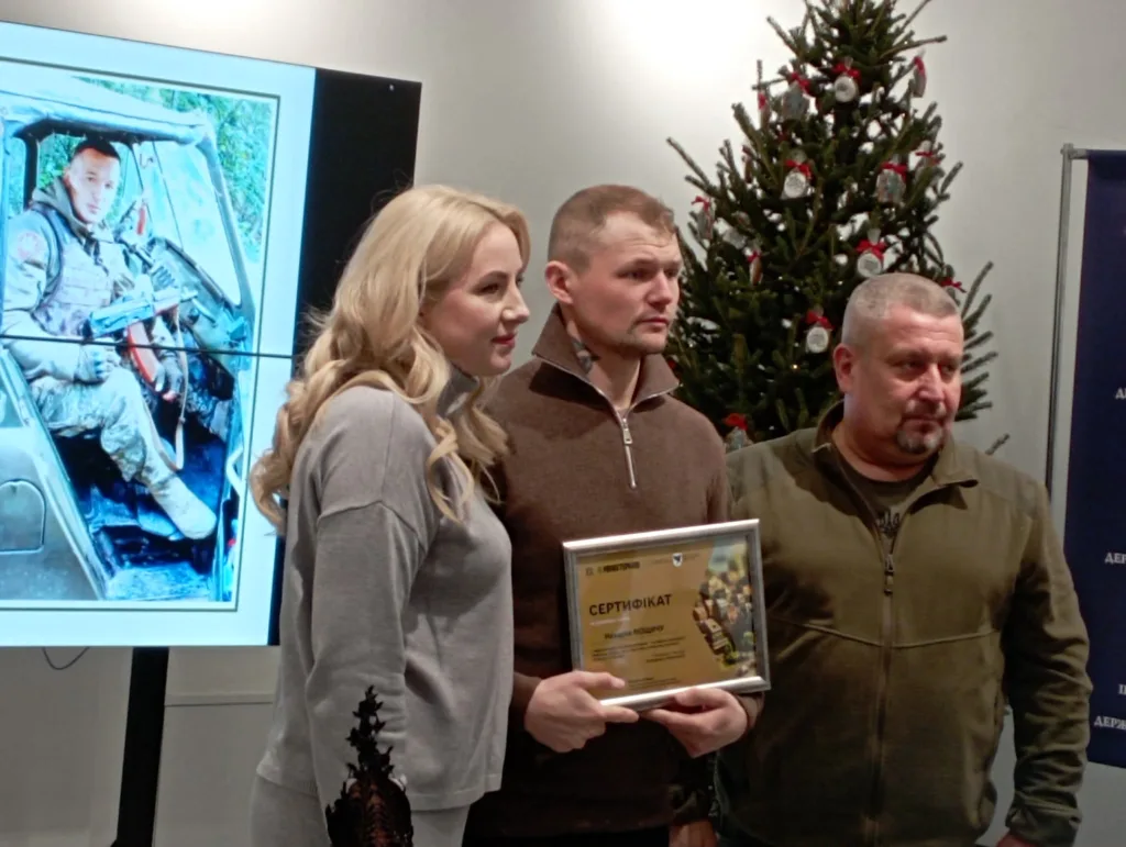 Вручення сертифіката біля новорічної ялинки