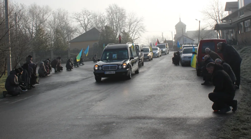 Прощальна процесія з українськими прапорами на вулиці