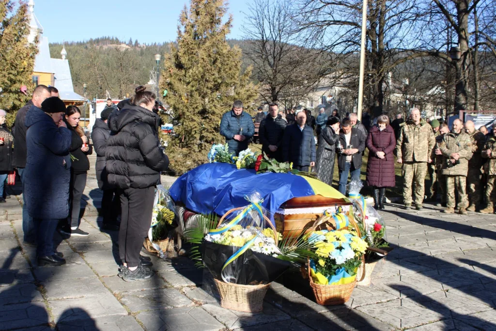 Прощання з українським військовим, накритим прапором України