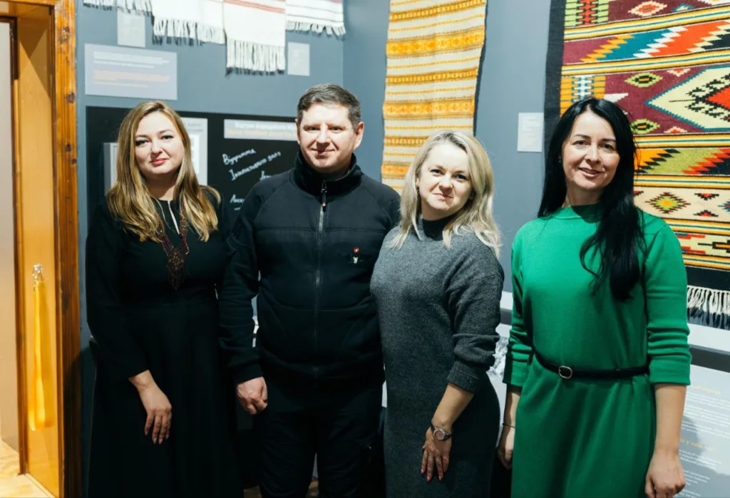 Група людей у музеї з традиційними килимами