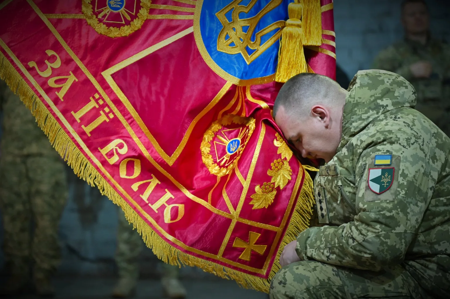 Український військовий вшановує бойовий прапор