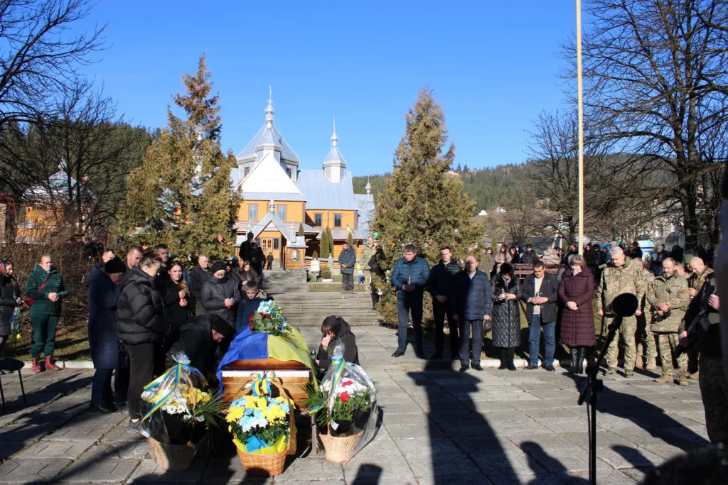 Похоронна церемонія біля церкви під синім небом