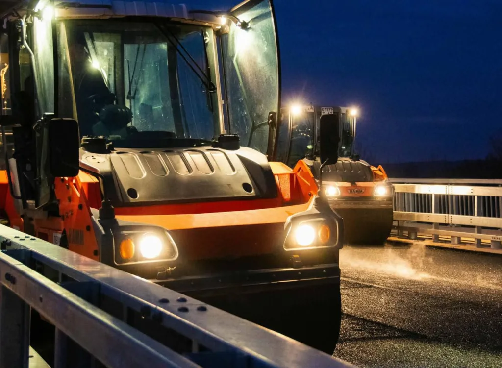 Дорожні котки укладають асфальт вночі