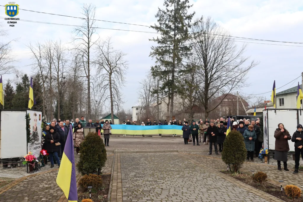 Люди тримають великий прапор України на вулиці