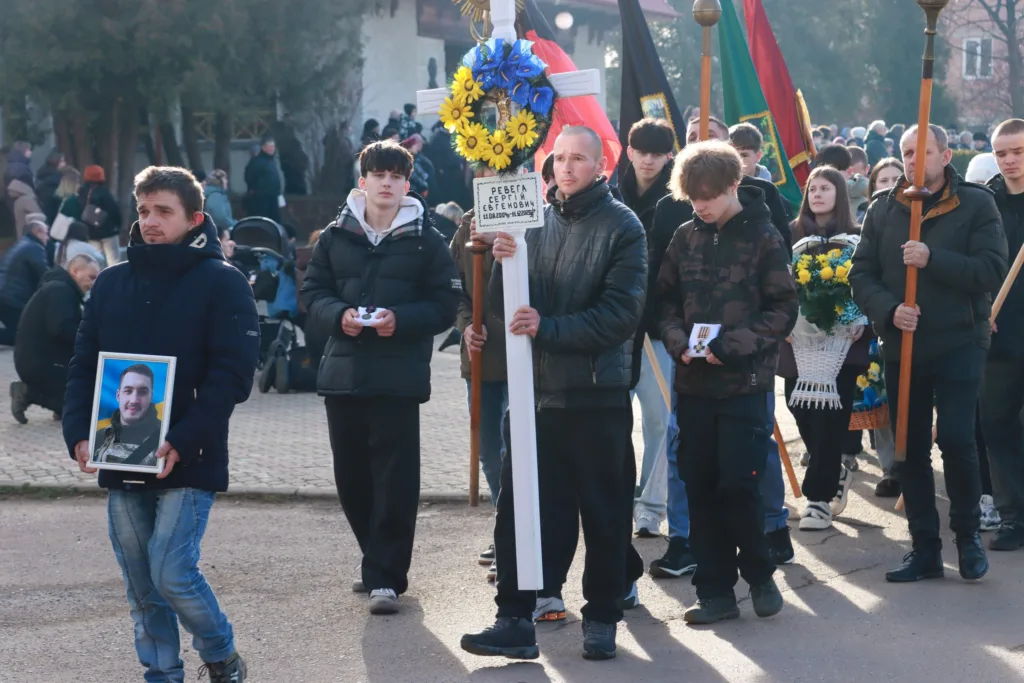 Процесія людей на похороні військового героя