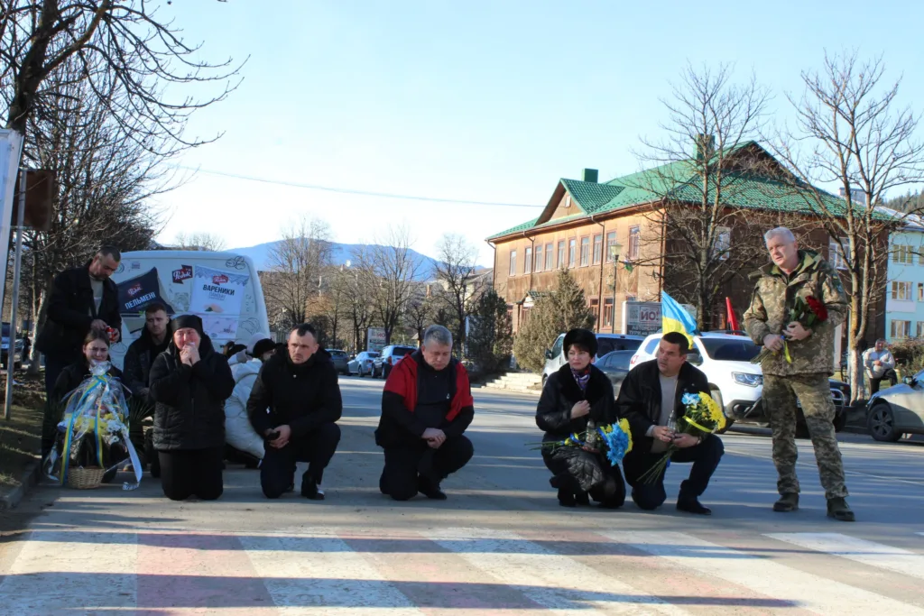 Люди на колінах вшановують пам’ять загиблого героя