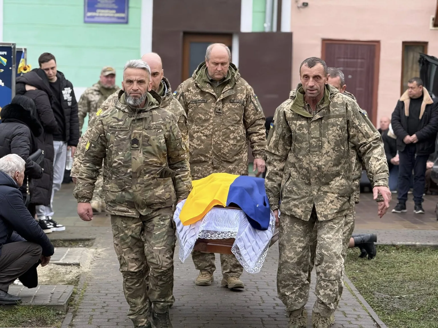 Військові несуть домовину, накриту прапором України