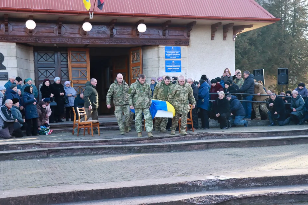 Військові несуть труну з українським прапором