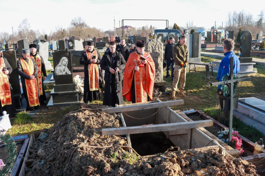 Священники проводять похоронну церемонію на цвинтарі