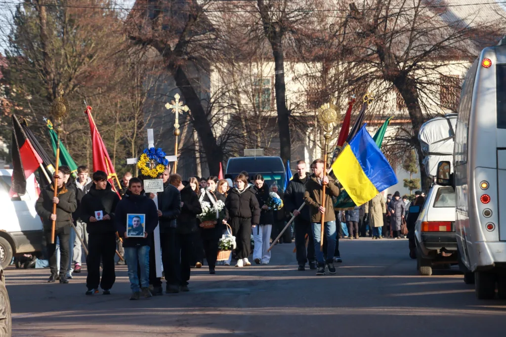 Похоронна процесія з українським прапором на вулиці