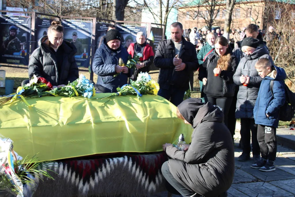 Прощання з загиблим воїном під українським прапором