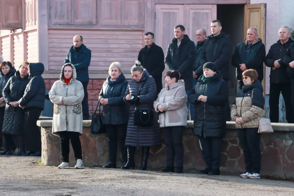 Люди стоять разом біля будівлі на вулиці