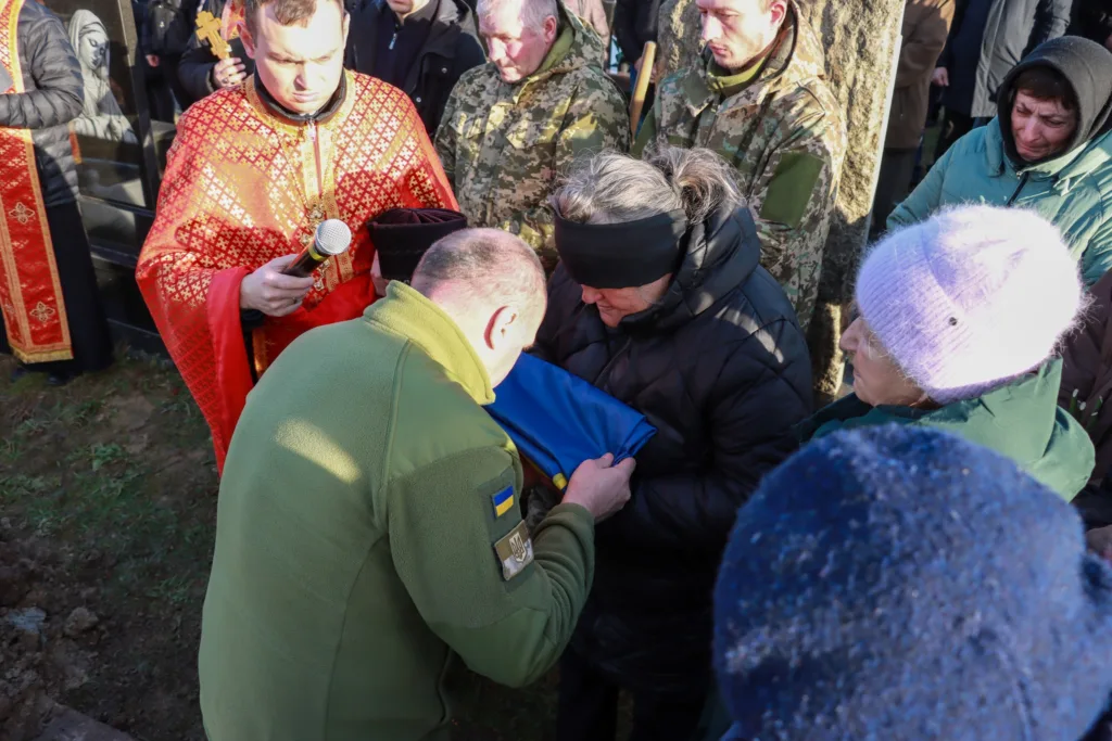 Вшанування полеглого військового з українським прапором