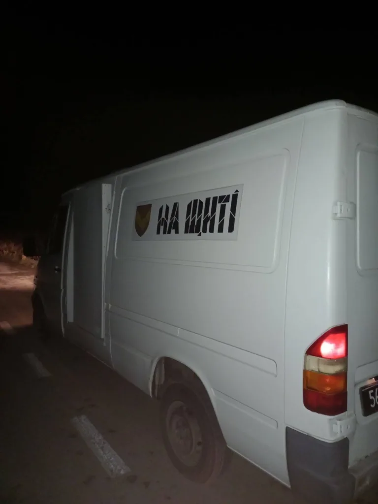 Білий фургон з написом на боці вночі