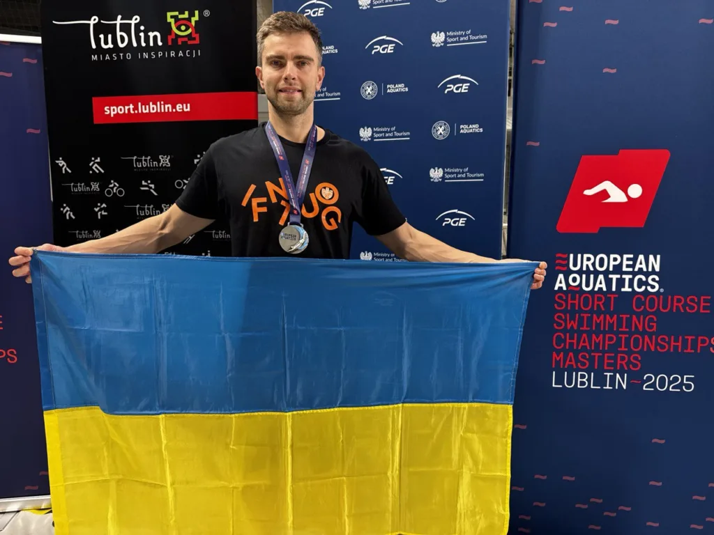 Український спортсмен з прапором на чемпіонаті з плавання