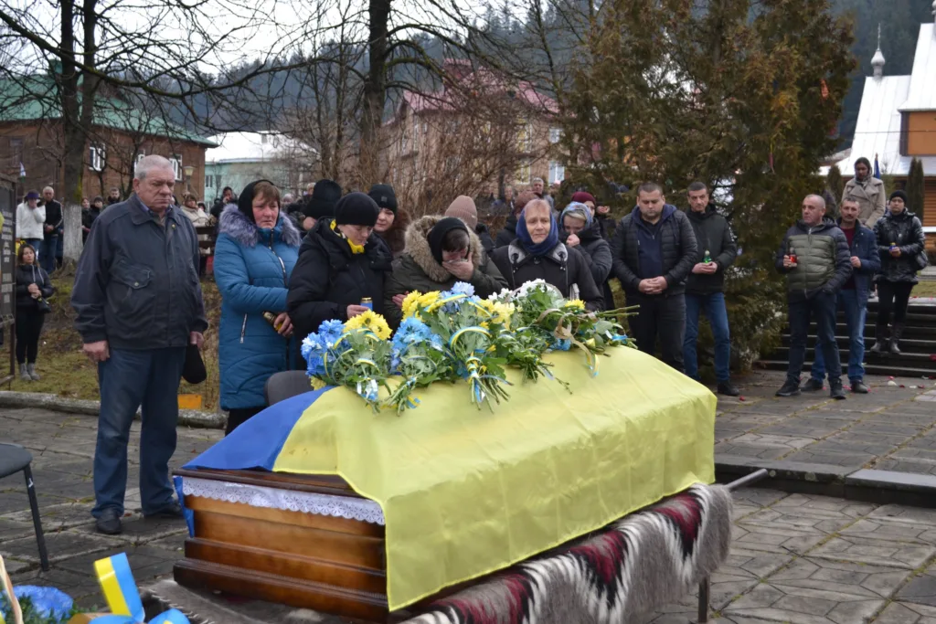 Похоронна церемонія з українським прапором і квітами