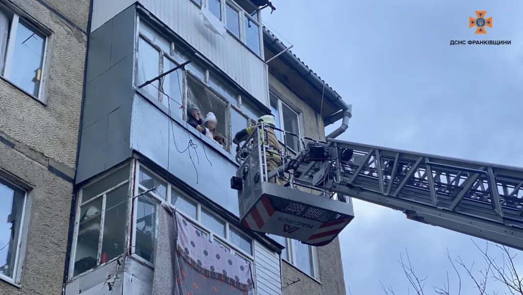 Рятувальник допомагає людям через вікно багатоповерхівки