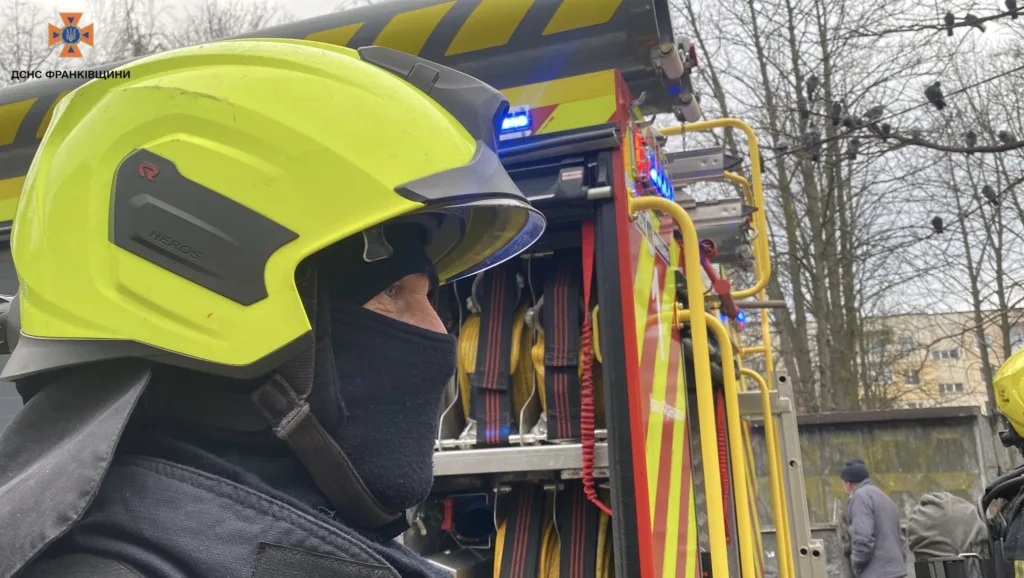 Пожежник біля пожежної машини під час роботи