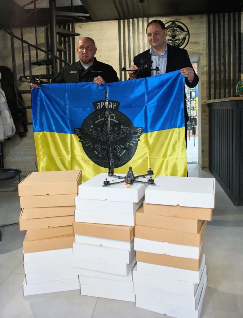 Двоє чоловіків з прапором України та дронами